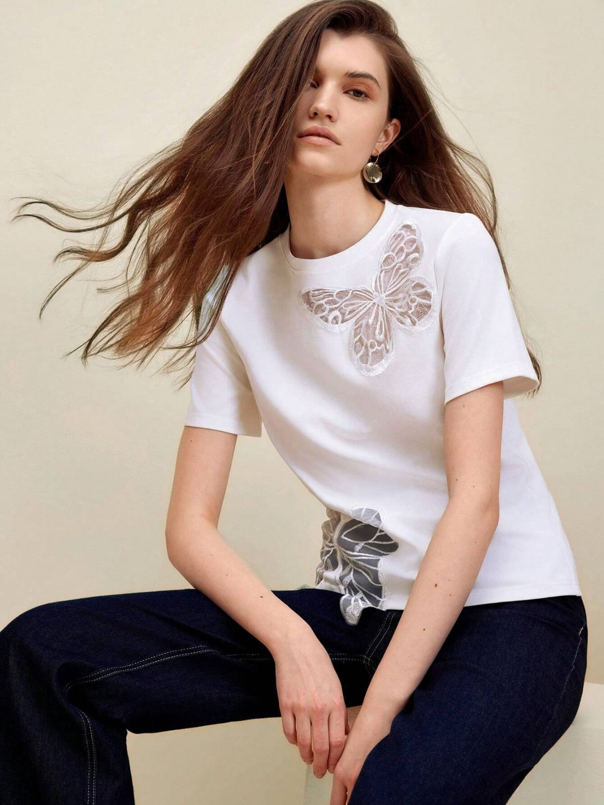 Camiseta blanca asimétrica con diseño bordado de corte mariposa